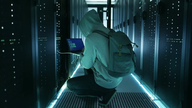 Hacker WIth Laptop Connects to Rack Server and  Steals Information from Corporate Data Center. Shot on RED EPIC-W 8K Helium Cinema Camera.