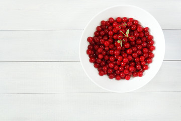 Fresh cherries in white bowl on white background. Cherries isolated on white. Healthy cherry fruits. Top view and space for text