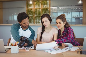 Graphic designers sitting at table and interacting