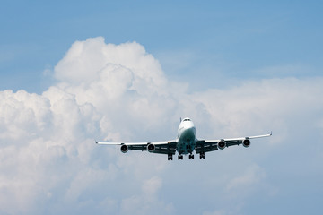 Heavy aircraft fly in front of rain cloud
