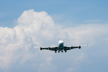Heavy aircraft fly in front of rain cloud