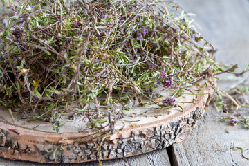 Pile of dried thyme seasoning on a wood background. Selective focus