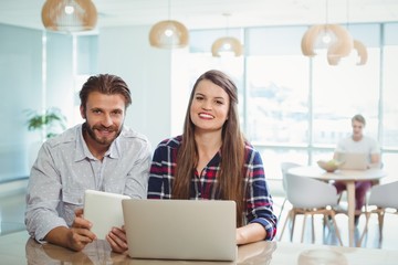 Obraz premium Portrait of business executives using laptop and digital tablet