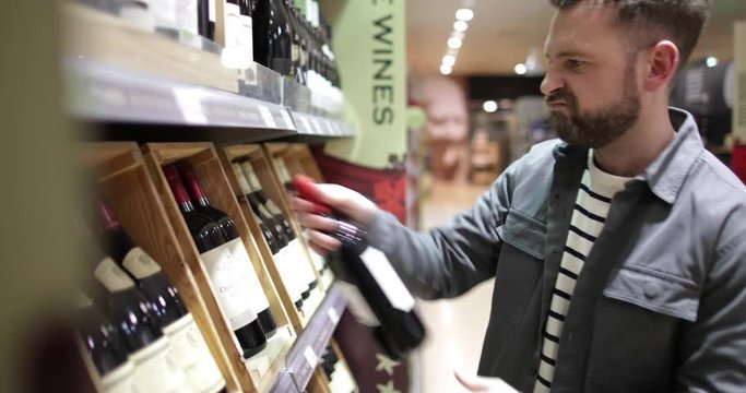 Man choosing wine in grocery store