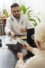 Pacjentka podaje pieniądze lekarzowi za wizytę lekarską. Babcia płaci lekarzowi za wizytę w...
