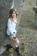 A Beautiful girl sits on an old bridge