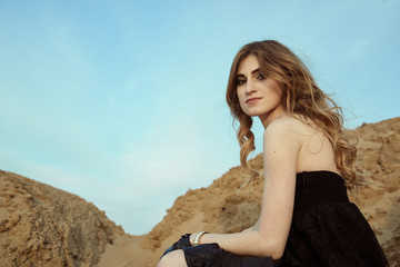 A Beautiful girl sits on an old bridge