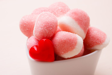 Pink jellies or marshmallows with sugar in bowl