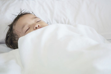 Obraz premium Closeup sick child sleep on hospital bed textured background