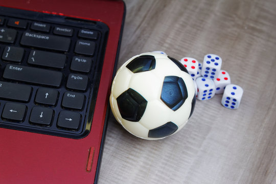 Concept of online gambling and games. Laptop, dice and soccer / football ball - Powered by Adobe