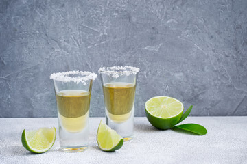 Mexican tequila gold in short glasses with salt and  lime slices, copy space