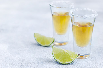 Mexican tequila gold in short glasses with salt and  lime slices, copy space