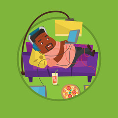 Man lying on sofa with many gadgets.