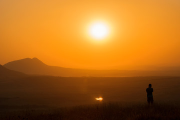 Sunset in the mountains, silhouette of man, summer warmth