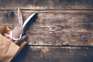 Easter bunny in a paper bag on old boards. Rabbit. Old board background. Easter ideas. Easter eggs....