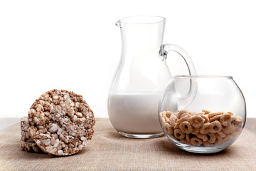 puffed wheat, corn and milk jug rings on the tablecloth from a sacking. Isolated