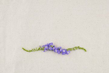 Purple flowers wreath of Duranta erecta L. on muslin fabric from top view with copy space