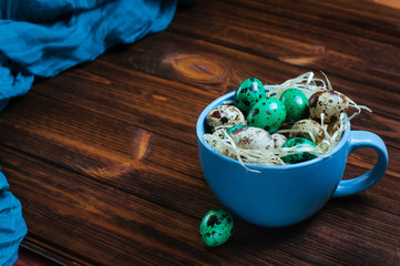 Painted quail eggs over rustic wooden background