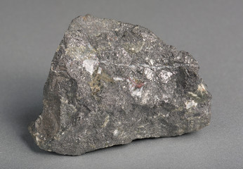 Mineral stone magnetite (lodestone)on gray background.  Magnetite is the most magnetic of all...