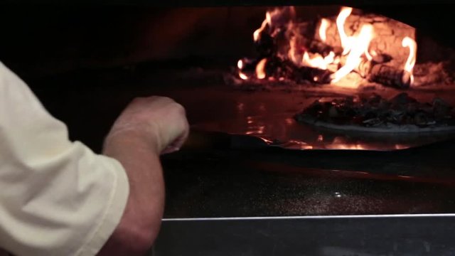 Loading Pizza Into Wood Fired Oven With Peel