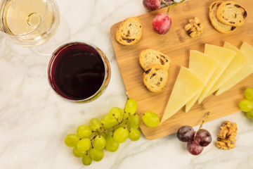 White and red wine with cheese, bread and grapes
