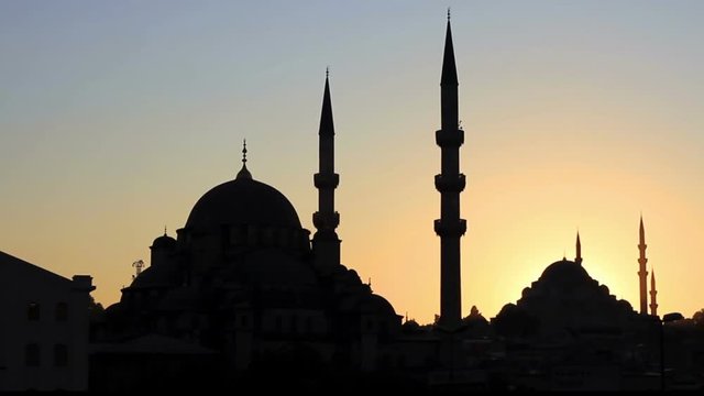 Mosques against sunset. Pan over minarets, domes, roofs
