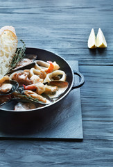 Seafood Stew in Saucepan on dark wood background
