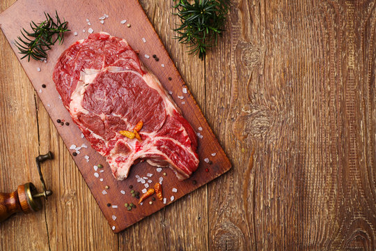 Fresh, raw beef steak on a wooden board