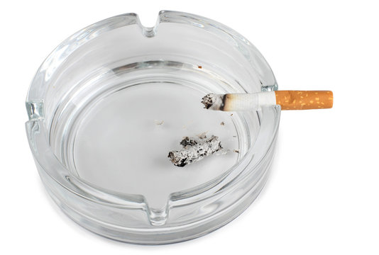 Glass ashtray and cigarette on white background