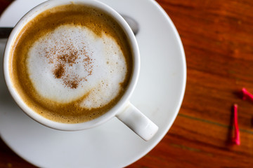 Hot coffee in cup on wooden table