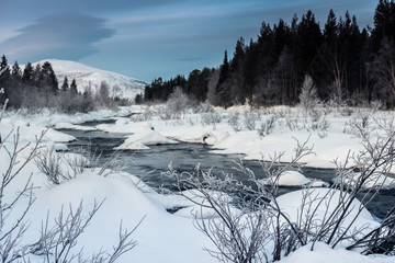 Winter landscape with unfrozen river in Russian Lapland, Kola Peninsula