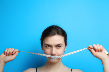  girl ties her mouth with a measuring tape