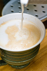 närbild på när en caffelatte tillverkas