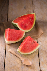 watermelon and watermelon pieces in a wooden background