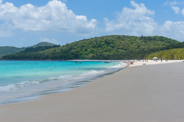 Tropical island beach with people in the distance. Summer background