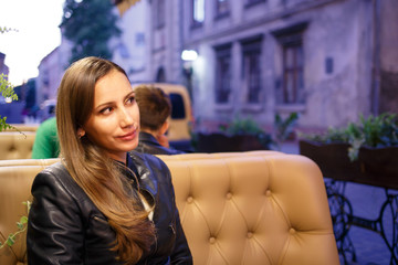 Young woman sitting in the patio of restaurant in the evening