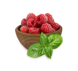 Raspberries in a wooden bowl isolated on white background. Raspberry with basil close-up. Vegetarian or healthy eating. Juicy and delicious raspberries