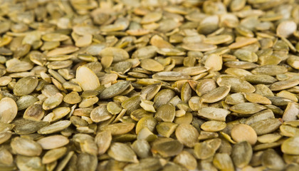 Pile of pumpkin seeds close-up as abstract food background