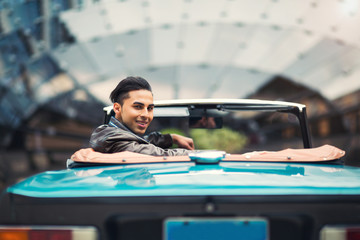 Fashion man sitting in luxury retro cabriolet car outdoors