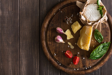 Cheese delikatessen closeup on rustic wood, brie and parmesan