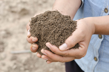 Farmer holding pile of arable soil female agronomist examining quality of fertile agricultural land