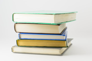 Many closed books lying on a white background.