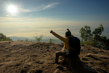 Naklejka na ściany i meble Man on the top of a rock to face the sunrise - success concept