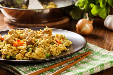 Fried rice nasi goreng with chicken and vegetables on a plate