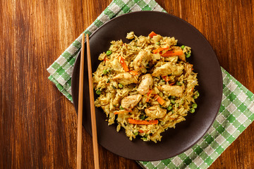 Fried rice nasi goreng with chicken and vegetables on a plate