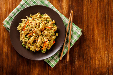 Fried rice nasi goreng with chicken and vegetables on a plate