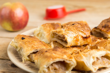 Slices of apple pie on the plate over wooden table