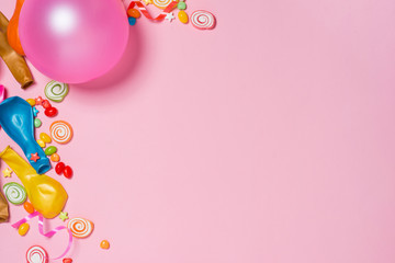 Celebration Flat lay. Candy with colorful party items on pink background.