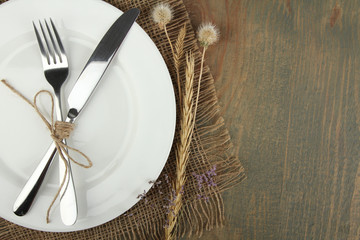  plate, knife and fork tied with twine and dried flowers and burlap