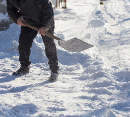 Worker cleans snow shovel